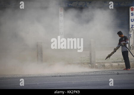 Biratnagar, Nepal. 28th Nov, 2017. A worker blows dust on a highway for road expansion in Biratnagar, Nepal on Tuesday, November 28, 2017. Credit: Skanda Gautam/ZUMA Wire/Alamy Live News Stock Photo