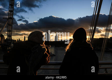 London, UK. 28th Nov, 2017. People watch a dramatic autumn sunset from Jubilee Bridge on a cold evening in LondonCredit: amer ghazzal/Alamy Live News Stock Photo