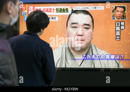 Tokyo, Japan. 29th November, 2017. Pedestrians look at a TV screen broadcasting a news conference of Mongolian Yokozuna (grand champion) Harumafuji on November 29, 2017, Tokyo, Japan. Harumafuji who is being investigated for assaulting a junior wrestler, Takanoiwa, during a drinking party in late October decided to quit sumo after weeks of speculation regarding the incident and his future. Credit: Rodrigo Reyes Marin/AFLO/Alamy Live News Stock Photo