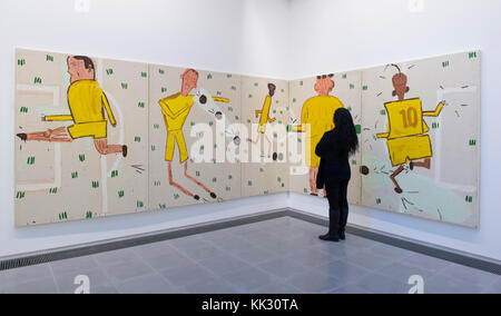 Serpentine Galleries, London, UK. 29 November, 2017. In her first major institutional/London show, British artist Rose Wylie presents her vibrant, large-scale, figurative paintings that depict a range of subjects, from the parkland of Kensington Gardens and an Arsenal vs Spurs match to Quentin Tarantino’s Kill Bill films and celebrity culture, including Elizabeth Taylor, Penelope Cruz and Nicole Kidman. Photo: Yellow Strip 2006. Courtesy of the Artist. Posed with gallery staff. Credit: Malcolm Park/Alamy Live News. Stock Photo