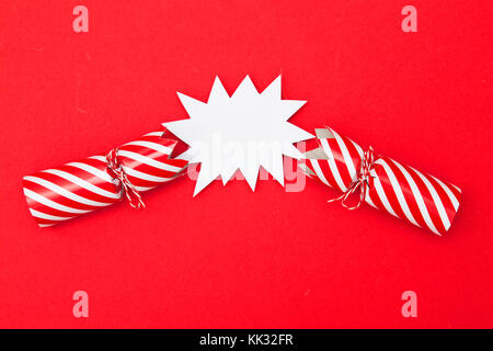 Popped Christmas crackers on a red background Stock Photo