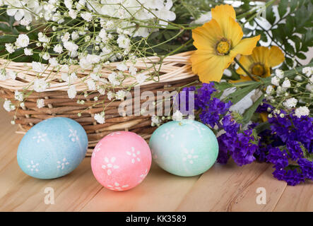 Three colored Easter eggs with flowers and basket Stock Photo