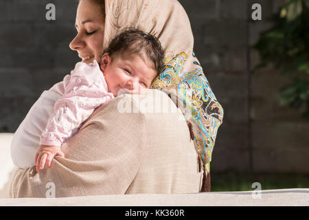 Muslim mother embraced a newborn baby in outdoor environment Stock Photo