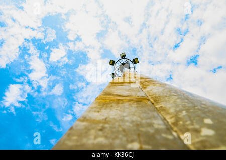 Sport lights of the stadium with rusty pole on beautiful blue sky and white cumulus with copy space for text. Stock Photo