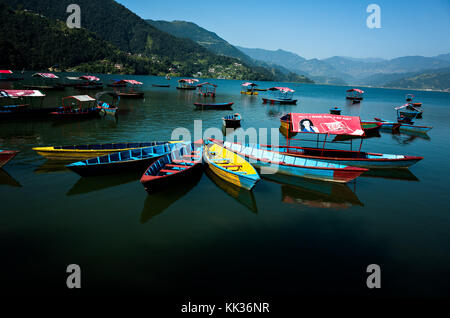 handmade manual rowboats aligned on Phewa Lake, popular tourist attraction, Mid-western region, Pokhara, Nepal Stock Photo