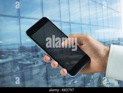 Digital composite of hand holding phone in front of building Stock Photo