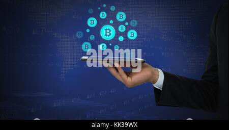 Digital composite of Bitcoin icons and hand holding tablet Stock Photo