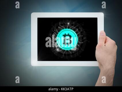 Digital composite of Bitcoin icon and hand holding tablet Stock Photo