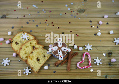 Christmas food and drink photography image with hot chocolate cup and mini marshmallows shaped as snowman with iced on smile with candy cane heart Stock Photo