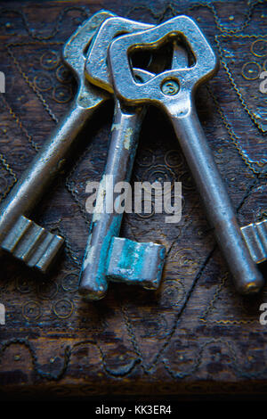 Three antique keys on wooden table Stock Photo