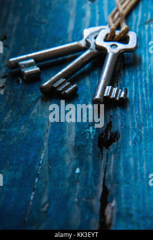 Three antique keys on wooden table Stock Photo