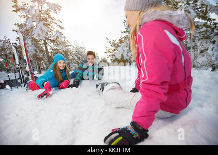 Happy mother with children on skiing resting on snow Stock Photo