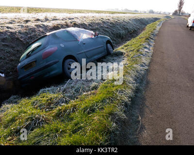 abandoned and damaged car in ditch on frosty day, Sussex, England Stock Photo