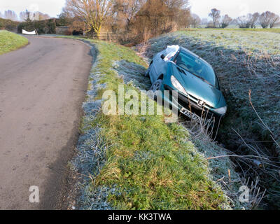 abandoned and damaged car in ditch on frosty day, Sussex, England Stock Photo