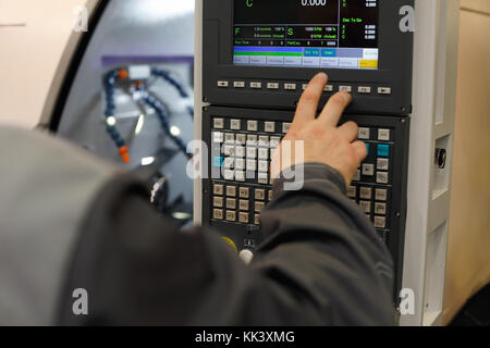 CNC operator programming lathe machine. Selective focus. Stock Photo