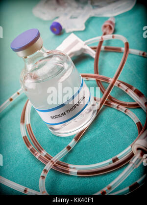 Rubber drip irrigation system with traces of blood along with vial of sodium thiopental, conceptual image Stock Photo