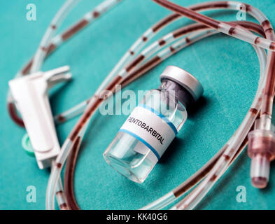 Rubber drip irrigation system with traces of blood along with vial of sodium thiopental, conceptual image Stock Photo