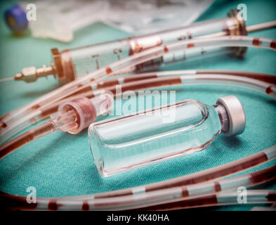 Rubber drip irrigation system with traces of blood along with vial, conceptual image Stock Photo