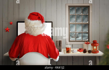 Christmas evening in Santa Claus room. Santa work on his computer. Snow and cold weather can be seen through the window. Stock Photo