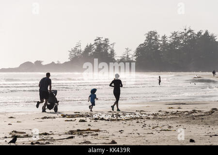 Chesterman beach near Tofino, BC, Canada (September 2017) - Family running on sand. Stock Photo