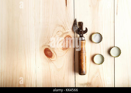 Vintage Opener near the lid of beer, on a wooden background, space for text Stock Photo