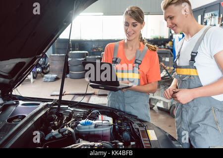 Experienced female auto mechanic checking the engine error codes Stock Photo
