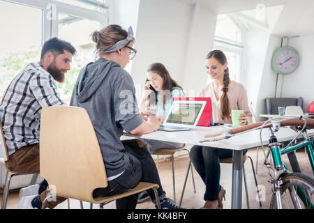 Dedicated young woman editing a document in a modern office spac Stock Photo