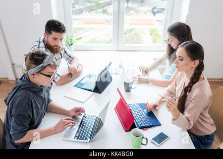 Dedicated young woman editing a document in a modern office spac Stock Photo