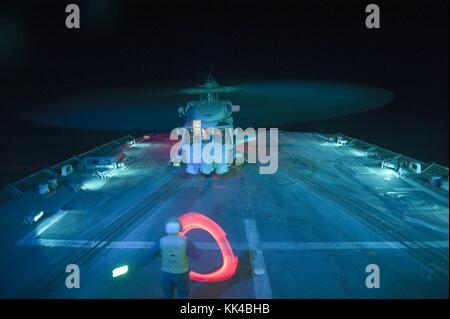 A Sailor directs an SH-60B Sea Hawk helicopter as it prepares to shut down after landing aboard the guided-missile destroyer USS Nitze DDG 94, Gulf Of Aden, 2012. Image courtesy Mass Communication Specialist 3rd Class Jeff Atherton/US Navy. Stock Photo