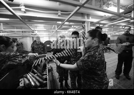 Aviation ordnancemen unload ammunition as part of training on the M-197 gun system in the weapons magazines aboard the aircraft carrier USS Nimitz CVN 68, Pacific Ocean, 2012. Image courtesy Mass Communication Specialist 2nd Class Robert Winn/US Navy. Stock Photo