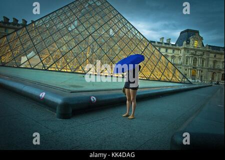 The Louvre in Paris -  04/08/2012  -    -  An indigo umbrella near the pyramid; during a the rainy day- summer 2012.   -  Sylvain Leser / Le Pictorium Stock Photo