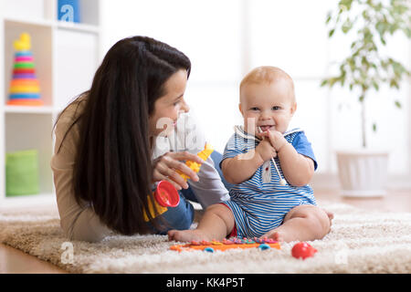 mom and baby playing musical toys at home Stock Photo