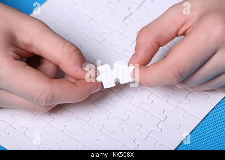 White details of a puzzle on a blue background. A puzzle is a pu Stock Photo