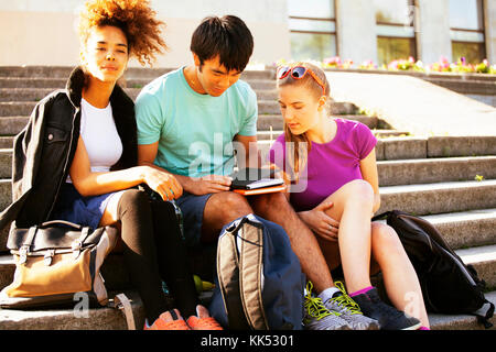 cute group of teenages at the building of university with books huggings, diversity nations Stock Photo