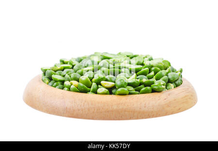 Dried split peas in a wooden dish on a white background. Stock Photo