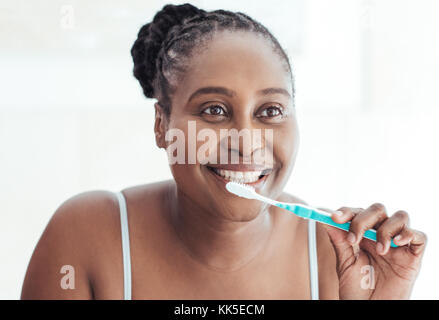 Young African woman brushing her teeth in the morning Stock Photo