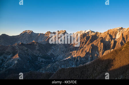 Apuane alpi or Apuan alps snowy mountains and marble quarry at sunset in winter. Carrara, Tuscany, Italy. Stock Photo