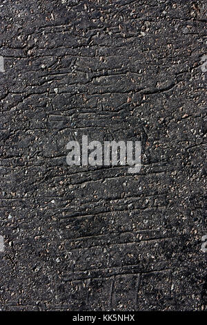 Tire imprints on old cracked asphalt road in black and white Stock Photo