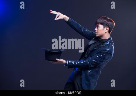 Young Chinese magician performing magic trick Stock Photo