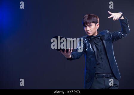 Young Chinese magician performing magic trick Stock Photo