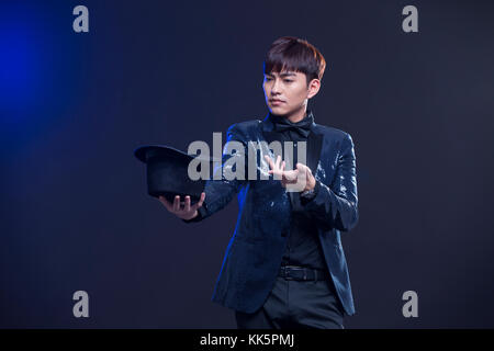 Young Chinese magician performing magic trick Stock Photo