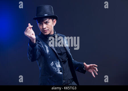 Young Chinese magician performing magic trick Stock Photo