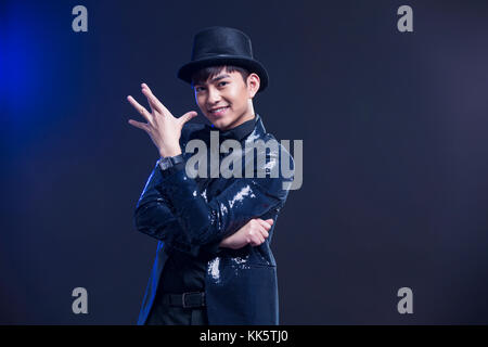 Young Chinese magician performing magic trick Stock Photo