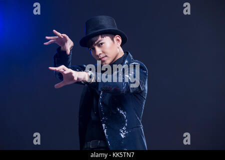 Young Chinese magician performing magic trick Stock Photo