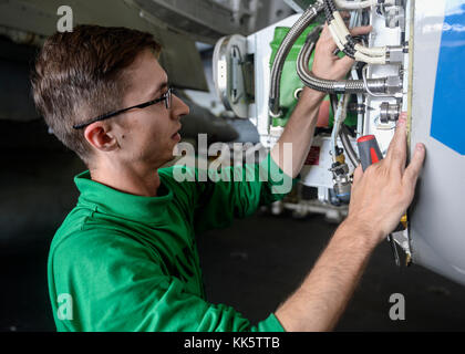 PACIFIC OCEAN (Nov. 22, 2017) Aviation Structural Mechanic (Equipment) 2nd Class Toby Rose removes the on board oxygen generating system concentrator from an E-2D Hawkeye early warning and attack aircraft assigned to the “Bluetails” of Carrier Airborne Early Warning Squadron (VAW) 121 in the hangar bay of the aircraft carrier USS Nimitz (CVN 68). The ship and its carrier strike group is on a deployment to the western Pacific. The U.S. Navy has patrolled the Indo-Asia-Pacific region routinely for more than 70 years promoting peace and security. (U.S. Navy photo by Mass Commun Stock Photo