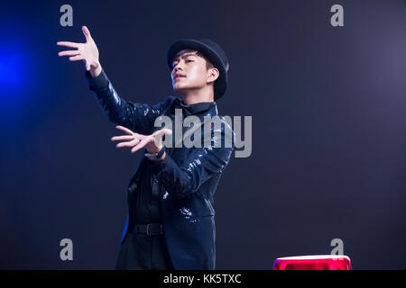 Young Chinese magician performing magic trick Stock Photo