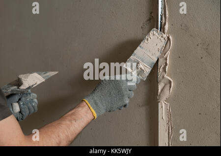 Man fixes a guide to align the walls with stucco in the future Stock Photo