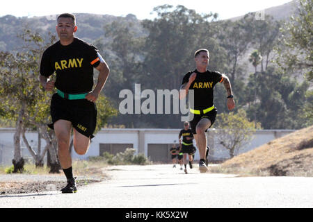 Sgt. George Ruiz, left, of the 49th Personnel Support Company, 115th Regional Support Group, California Army National Guard, battles Spc. Devon Witt to the finish line of the 2-mile run of the Army Physical Fitness Test Nov. 5 during the 2017-18 Best Warrior Competition at Camp San Luis Obispo, California. (Army National Guard photo by Staff Sgt. Eddie Siguenza) Stock Photo