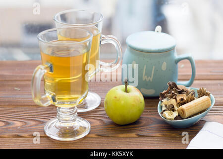 Two glass tea cups,an apple, sugar bowl and a cookie Stock Photo