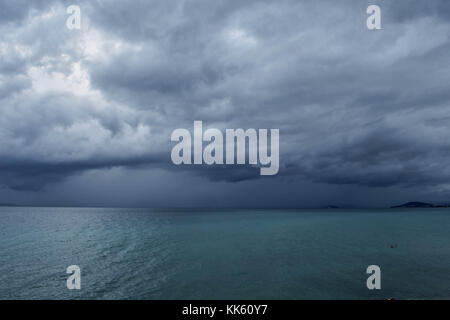 Dark sky at stormy weather with huge heavy clouds over the sea Stock Photo